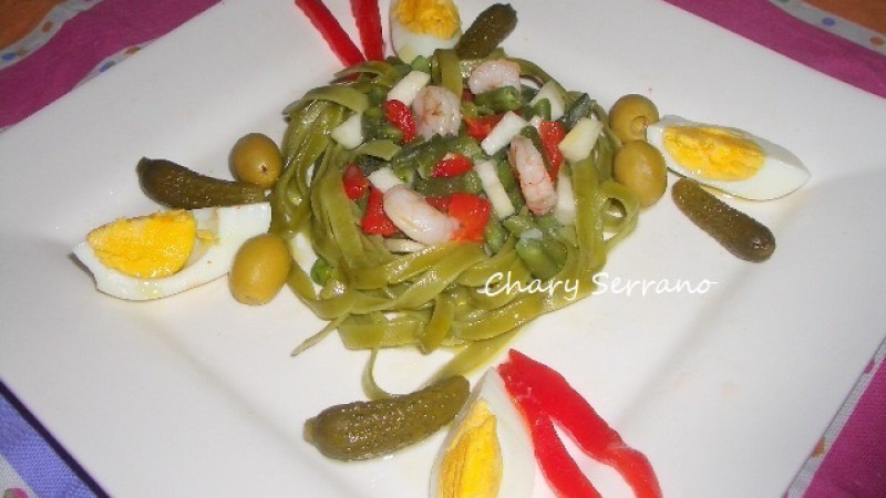 nidos de tagliatelle de espinacas con vegetales y gambas